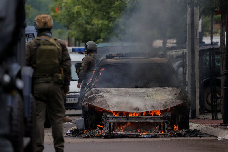 &copy; Reuters. Special police forces officers stand next to a burning car, following clashes between Kosovo police and ethnic Serb protesters, who tried to prevent a newly-elected ethnic Albanian mayor from entering his office, in the town of Zvecan, Kosovo, May 26, 202