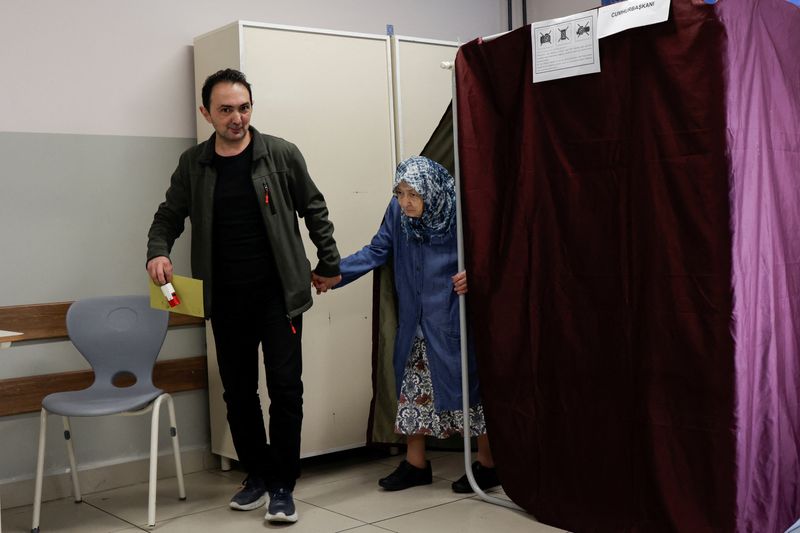 © Reuters. Hava Tok, 83, is helped by her son Safak as she leaves the voting booth at a polling station during the second round of the presidential election in Istanbul, Turkey May 28, 2023. REUTERS/Murad Sezer