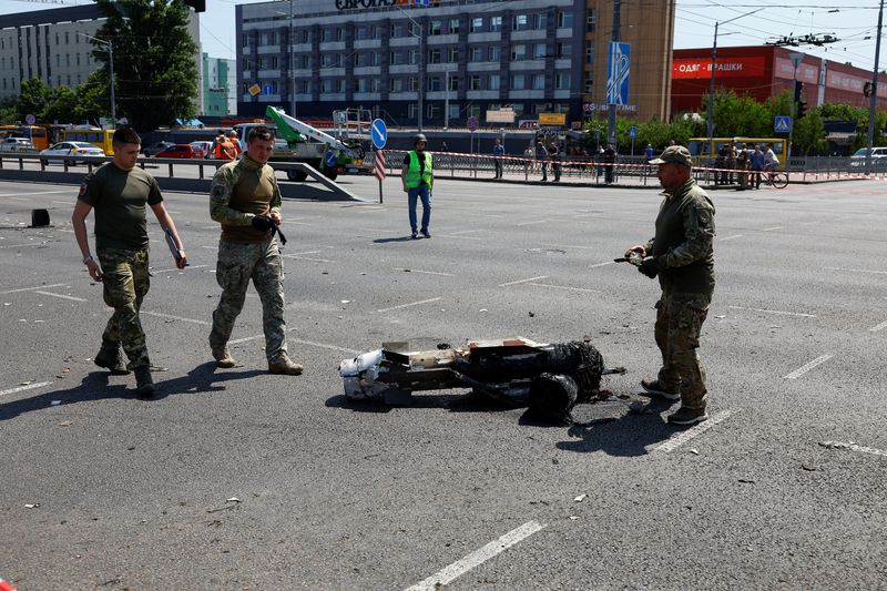 © Reuters. أفراد الشرطة يقفون بجانب حطام صاروخ سقط خلال هجوم روسي على مدينة كييف بأوكرانيا يوم الاثنين. تصوير: فالنتين أوجيرينكو - رويترز.