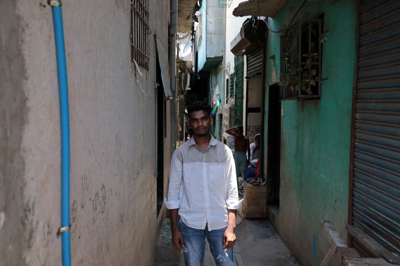 &copy; Reuters. Nizamudin Abdul Rahim Khan, 23, a worker, poses for a photograph in an alley at a slum area in Mumbai, India, May 20, 2023. REUTERS/Niharika Kulkarni