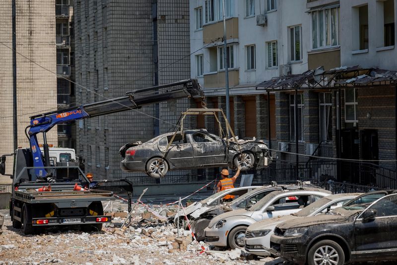 &copy; Reuters. Employees of city services remove destroyed cars from the parking next to an apartment building heavily damaged during a massive Russian drone strike, amid Russia's attack on Ukraine, in Kyiv, Ukraine May 30, 2023. REUTERS/Alina Smutko     