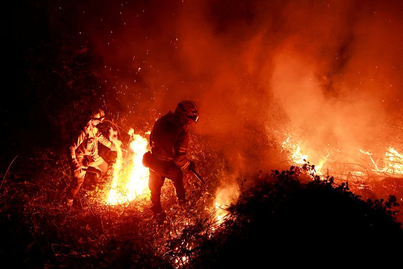 &copy; Reuters. FILE PHOTO: Galician firefighters tackle flames in a forest during an outbreak of wildfires following a prolonged period of drought and unusually high temperatures, in Piedrafita, Asturias, Spain, March 31, 2023. REUTERS/Vincent West/File Photo