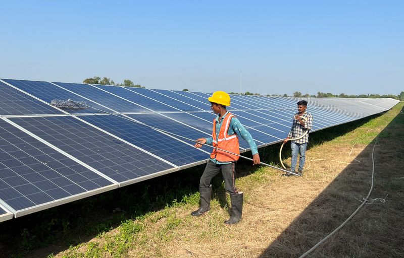 &copy; Reuters. Trabalhadores limpam painéis em parque solar em Modhera, primeira vila movida a energia solar 24 horas por dia da Índia
19/10/2022
REUTERS/Sunil Kataria