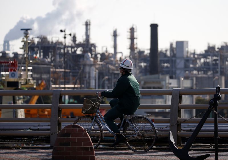 © Reuters. FILE PHOTO: A worker cycles near a factory at the Keihin industrial zone in Kawasaki, Japan February 28, 2017. REUTERS/Issei Kato