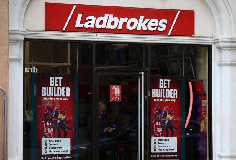 &copy; Reuters. FILE PHOTO-A person stands inside a Ladbrokes betting shop in London, Britain, March 4, 2023. REUTERS/Henry Nicholls