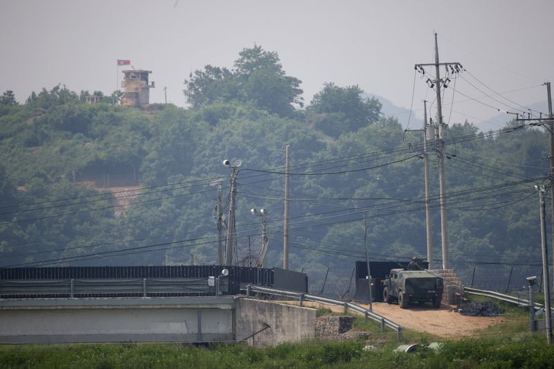 &copy; Reuters. جندي كوري جنوبي داخل عربة مدرعة في مهمة حراسة بينما تظهر نقطة حراسة تابعة لكوريا الشمالية في الصورة الملتقطة بالقرب من المنطقة منزوعة السلا