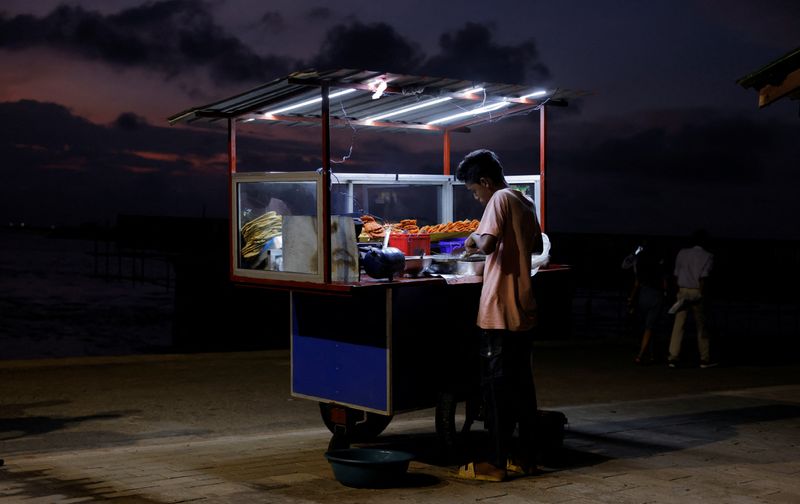 &copy; Reuters. FILE PHOTO: A vendor cooks food for customers in his food cart at Galle Face Green, amid the country's economic crisis, in Colombo, Sri Lanka, October 31, 2022. REUTERS/ Dinuka Liyanawatte