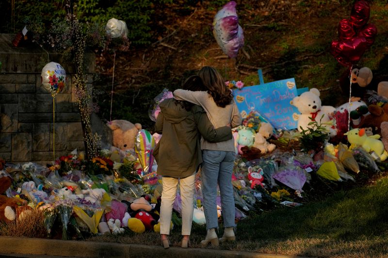 &copy; Reuters. FILE PHOTO: Community members embrace while visiting a memorial at the school entrance after a deadly shooting at the Covenant School in Nashville, Tennessee, U.S. March 29, 2023. REUTERS/Cheney Orr