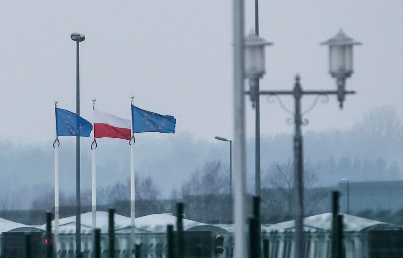 &copy; Reuters. FILE PHOTO: A view from the Belarusian side of the frontier shows Polish and EU flags behind a fence at the Bruzgi-Kuznica checkpoint on the Belarusian-Polish border amid the migrant crisis in the Grodno region, Belarus, December 23, 2021. REUTERS/Maxim S