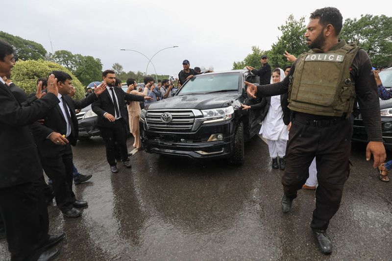 &copy; Reuters. ضباط شرطة يفسحون الطريق أمام سيارة تقل رئيس الوزراء الباكستاني السابق عمران خان أثناء مغادرته مقر المحكمة العليا في إسلام اباد يوم الأربعا