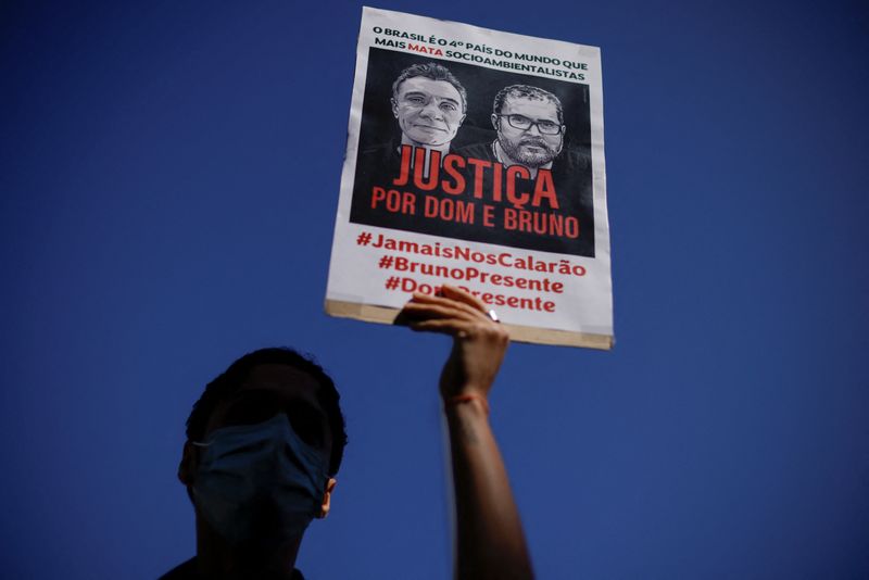 &copy; Reuters. FILE PHOTO: A demonstrator holds a sign during a protest, to demand justice for journalist Dom Phillips and indigenous expert Bruno Pereira, who were murdered in the Amazon, in Brasilia, Brazil June 19, 2022. REUTERS/Ueslei Marcelino/File Photo