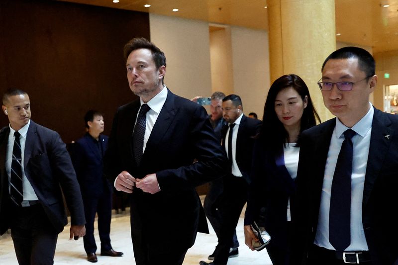 © Reuters. FILE PHOTO: Tesla Chief Executive Officer Elon Musk walks next to Tesla's Senior Vice President Tom Zhu and Vice President Grace Tao as he leaves a hotel in Beijing, China May 31, 2023. REUTERS/Tingshu Wang/File Photo