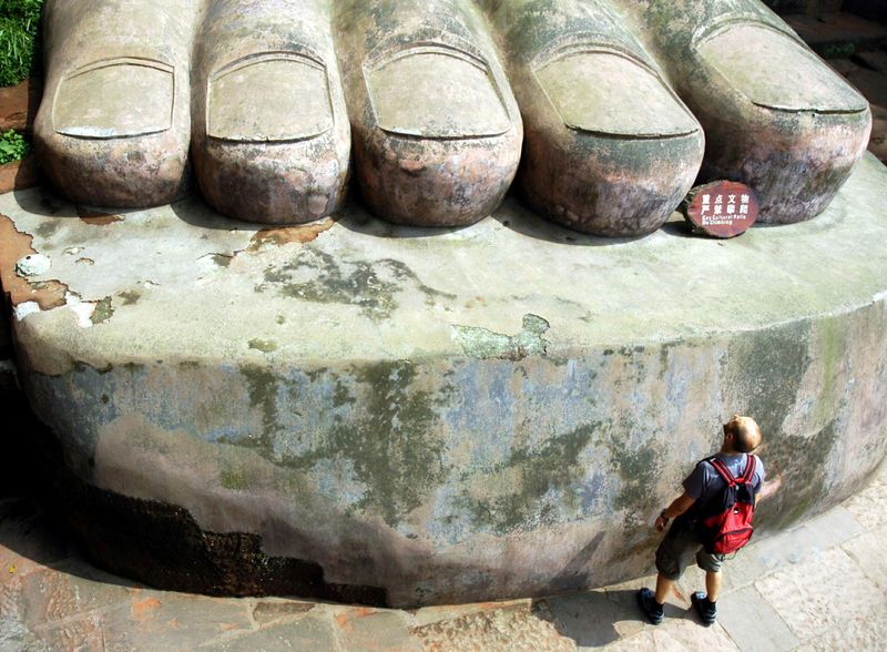 &copy; Reuters. FILE PHOTO: A visitor looks at the foot of the Leshan Giant Buddha statue in Leshan in southwest China's Sichuan province August 29, 2005.