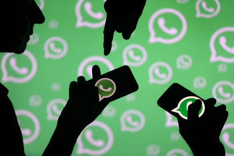&copy; Reuters. FILE PHOTO: Men pose with smartphones in front of displayed Whatsapp logo in this illustration September 14, 2017. REUTERS/Dado Ruvic/File Photo