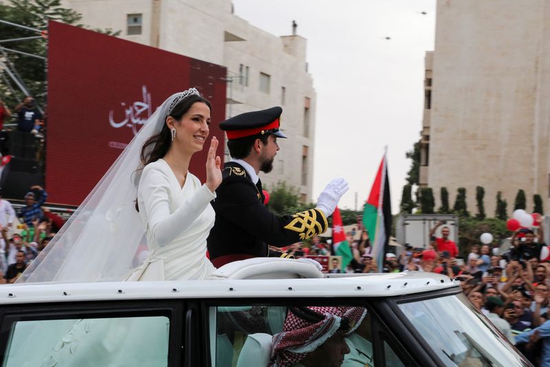 © Reuters. Jordan's Crown Prince Hussein and Rajwa Al Saif travel in a convoy, on the day of their royal wedding in Amman, Jordan, June 1, 2023. REUTERS/Ahmad Abdo