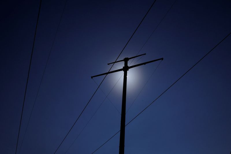 &copy; Reuters. FILE PHOTO: A newly installed pole for transmission lines for the New England Clean Energy Connect project (also known as the Clean Energy Corridor), which will bring hydroelectric power to the New England power grid, stand next to existing power lines in