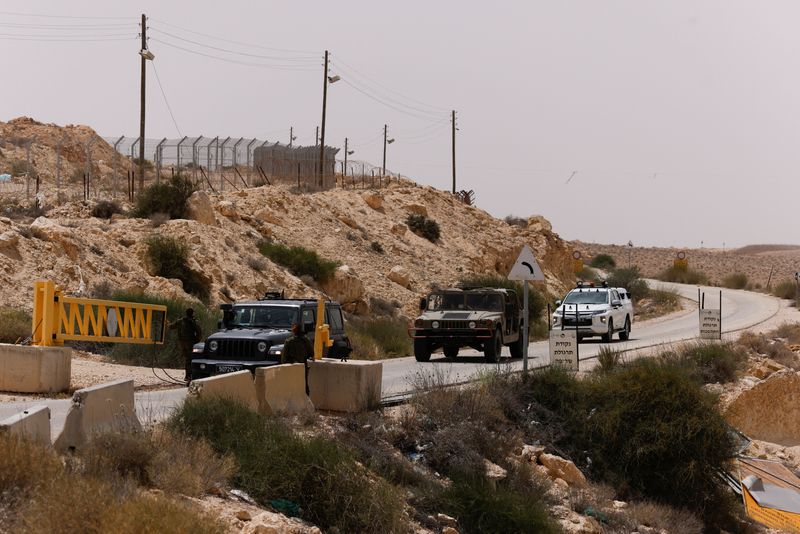 © Reuters. سيارات عسكرية تتجه نحو بوابة قرب موقع شهد حادثا أمنيا يوم السبت بالقرب من الحدود الجنوبية لإسرائيل و مصر . تصوير : عمير كوهين - رويترز.