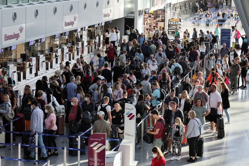 © Reuters. FILE PHOTO: Passengers queue at Duesseldorf Airport during a warning strike staged by Lufthansa ground staff, July 27, 2022. REUTERS/Wolfgang Rattay