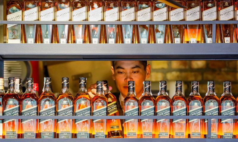 © Reuters. FILE PHOTO: A bartender takes a bottle of Johnnie Walker whisky in Almaty, Kazakhstan June 22, 2017.  REUTERS/Shamil Zhumatov