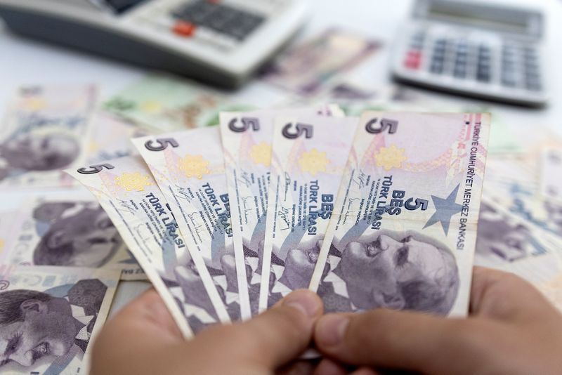 &copy; Reuters. شخص يحمل أوراقا نقدية من فئة الليرة التركية في صورة توضيحية من أرشيف رويترز. 