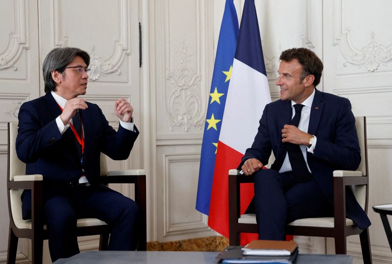 © Reuters. FILE PHOTO: France's President Emmanuel Macron speaks with ProLogium's CEO Vincent Yang during a meeting as part of the 5th edition of the 