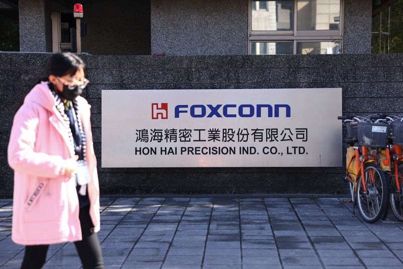 &copy; Reuters. FILE PHOTO: A woman walks past the logo of Foxconn outside a company's building, in New Taipe City, Taiwan December 22, 2022. REUTERS/Annabelle Chih
