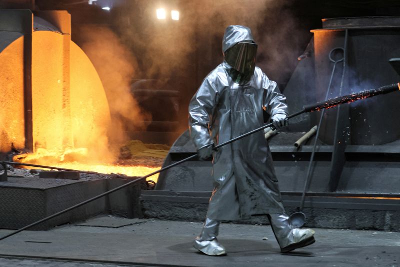© Reuters. FILE PHOTO: A steel worker of ThyssenKrupp walks in front of a blast furnace at a ThyssenKrupp steel factory in Duisburg, western Germany, November 14, 2022. REUTERS/Wolfgang Rattay/File Photo