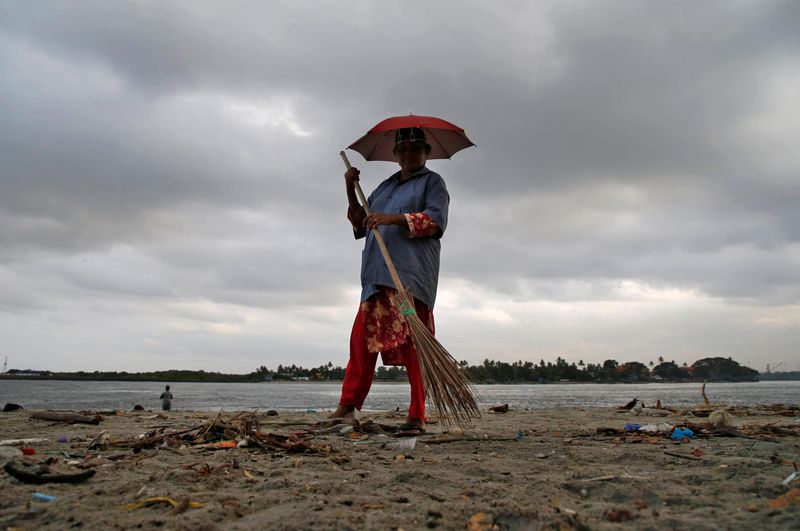 &copy; Reuters. FOTO DE ARCHIVO: Un trabajador limpia una playa, con el telón de fondo de las nubes previas al monzón, en la playa de Fort Kochi en Kochi, India, 9 de mayo de 2019. REUTERS/Sivaram V/Foto de archivo