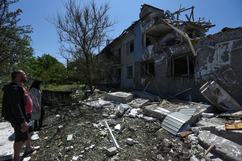 &copy; Reuters. FILE PHOTO: Local residents stand next to an apartment building heavily damaged by a Russian missile strike, amid Russia's attack on Ukraine, in the town of Pidhorodnie, outside of Dnipro, Ukraine June 4, 2023. REUTERS/Mykola Synelnykov