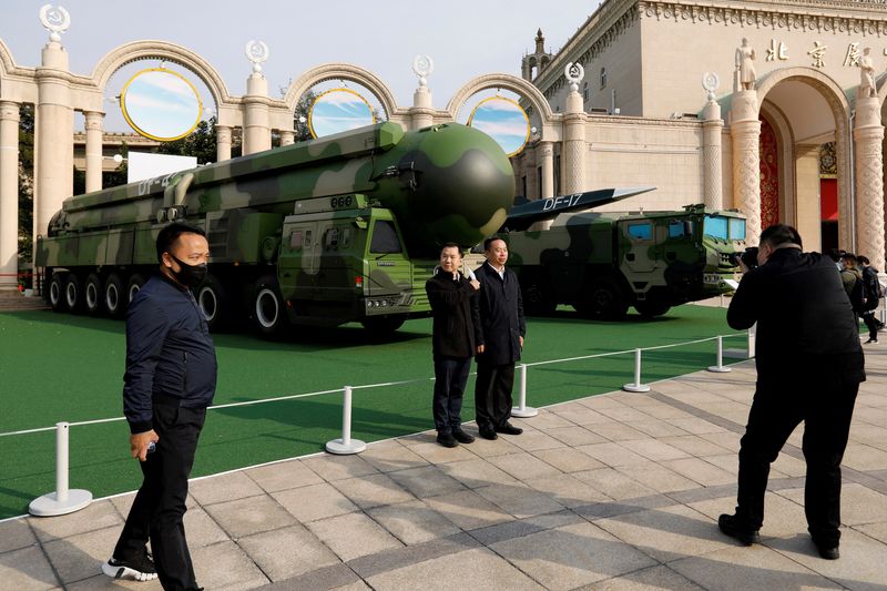 &copy; Reuters. FILE PHOTO: Visitors pose for pictures near displays of military vehicles carrying DF-41 intercontinental ballistic missile and DF-17 hypersonic missile at an exhibition titled "Forging Ahead in the New Era" during an organised media tour ahead of the 20t