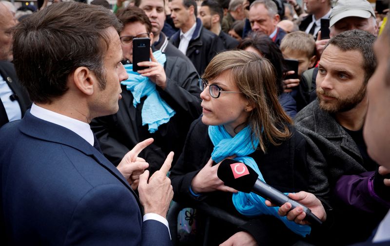&copy; Reuters. FILE PHOTO: French President Emmanuel Macron talks to a person opposed to the pension reform, in Selestat, eastern France, April 19, 2023. Ludovic Marin/Pool via REUTERS