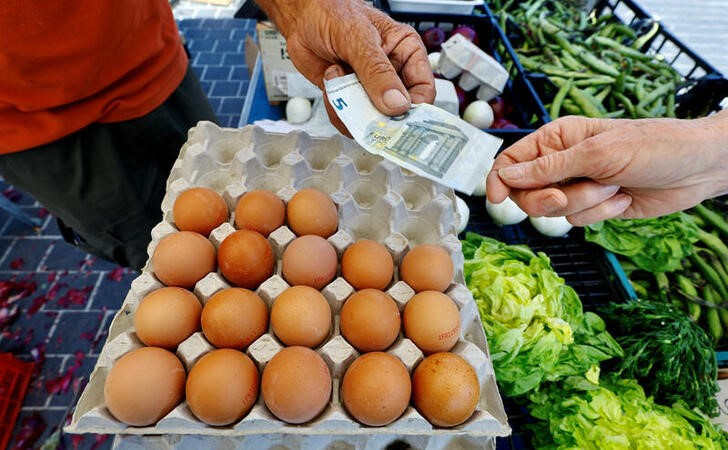 © Reuters. A shopper pays with a five Euro bank note to buy eggs at a local market in Nice, France, April 26, 2023.  REUTERS/Eric Gaillard