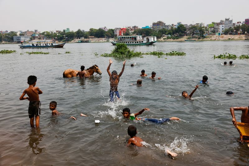 &copy; Reuters. أطفال يسبحون في نهر بوريجانجا خلال موجة حر شديد في داكا ببنجلادش يوم الثلاثاء. تصوير: محمد بونير حسين - رويترز.