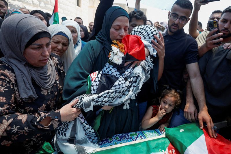 &copy; Reuters. والدة الطفل الفلسطيني محمد التميمي تحتضن جثمانه أثناء تشييع جنازته بالقرب من رام الله بالضفة الغربية يوم الثلاثاء. تصوير: محمد توركمان - روي