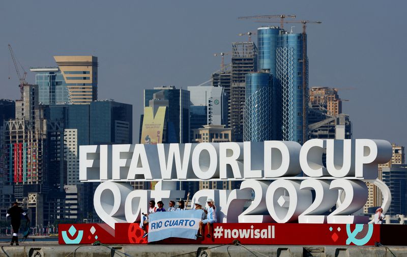 &copy; Reuters. Des supporters argentins posent à côté d'un panneau de la Coupe du Monde sur la Corniche, au Qatar. /Photo d'archives/REUTERS/Fabrizio Bensch