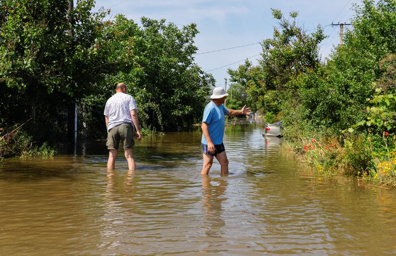 &copy; Reuters. Local resident Valery, 53, who didn't give his family name, gestures while standing in a flooded street near his house that submerged in water following the collapse of the Nova Kakhovka dam in the course of Russia-Ukraine conflict, in the town of Nova Ka