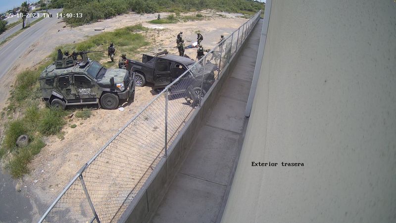 © Reuters. Soldiers drag a person whom they pulled out from a pick-up truck after it crashed into a wall at high speed in Nuevo Laredo, Tamaulipas, Mexico May 18, 2023, in this screen grab obtained from a handout video. Diario El Pais/Handout via REUTERS  