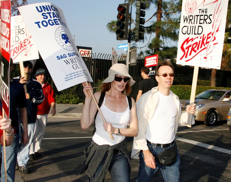 &copy; Reuters. FILE PHOTO: Actress Marg Helgenberger (L), star of the CBS TV network series "CSI: Crime Scene Investigation" and a member of the Screen Actors Guild, walks a picket line along with members of the Writers Guild of America at one of the gates to Universal 
