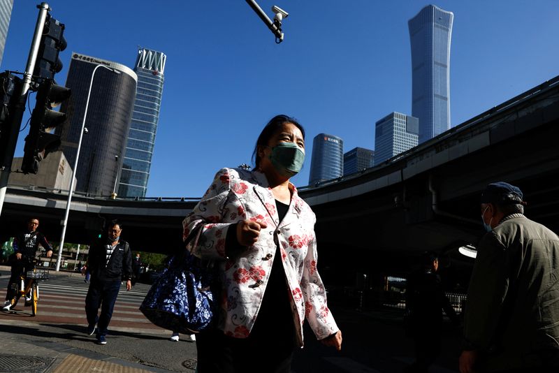 &copy; Reuters. FILE PHOTO: A woman walks past a street at the Beijing's Central Business District (CBD) during morning rush hour, in Beijing, China April 18, 2023. REUTERS/Tingshu Wang