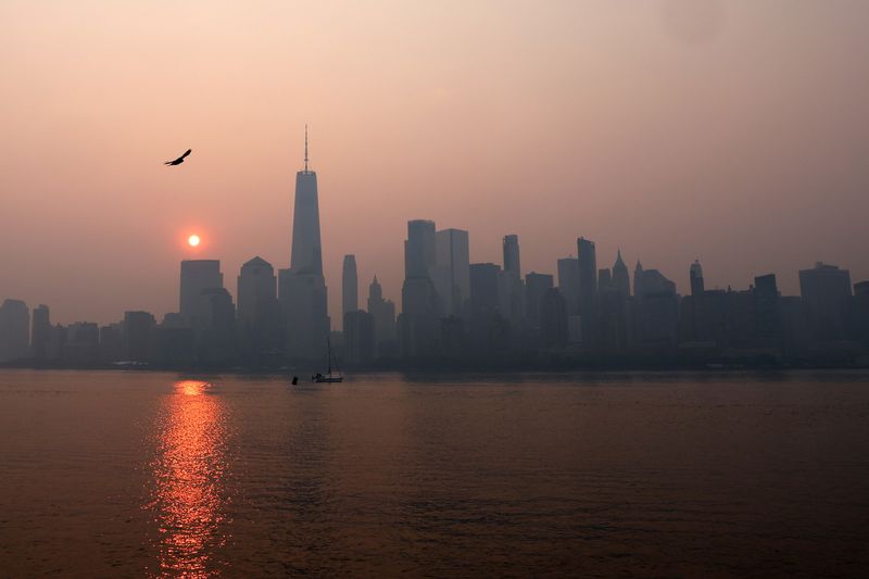 © Reuters. The One World Trade Center tower in lower Manhattan in New York City is pictured shortly after sunrise as haze and smoke caused by wildfires in Canada hangs over the Manhattan skyline in as seen from Jersey City, New Jersey, U.S., June 8, 2023. REUTERS/Mike Segar