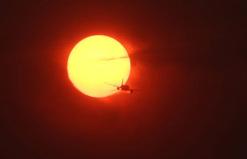 &copy; Reuters. A commercial plane flies past a sun made dark orange by smoke from wildfires in Canada as seen from Washington, U.S., June 7, 2023. REUTERS/Leah Millis/File Photo