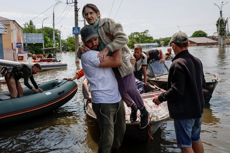 &copy; Reuters. Voluntários retiram moradores de área inundada após  rompimento da barragem de Nova Kakhovka, em Kherson
08/06/2023
REUTERS/Alina Smutko