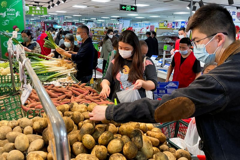 &copy; Reuters. FILE PHOTO: Customers wearing face masks shop at the vegetables section of a supermarket following the coronavirus disease (COVID-19) outbreak in Beijing, China April 25, 2022. REUTERS/Carlos Garcia Rawlins