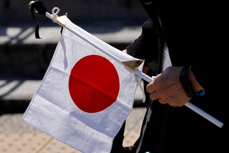 &copy; Reuters. شخص يحمل علم اليابان في طوكيو يوم 27 سبتمبر أيلول 2022. تصوير: ايزي كاتو - رويترز.