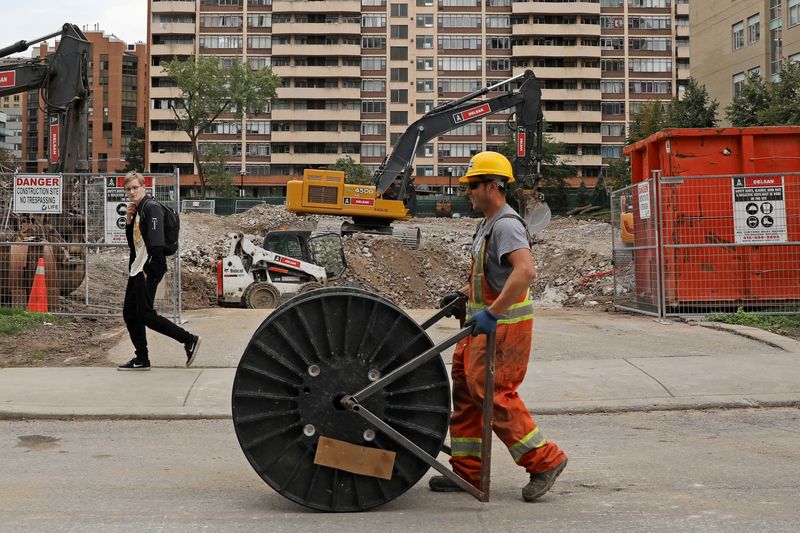 &copy; Reuters. A construction worker passes a condominium site with a roll of cable in Toronto, Ontario, Canada October 8, 2021.  REUTERS/Chris Helgren