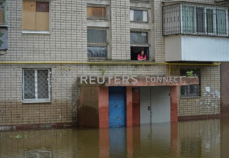 &copy; Reuters. A local resident looks out of a window of an apartment building in a flooded area after the Nova Kakhovka dam breached, amid Russia's attack on Ukraine, in Kherson, Ukraine June 10, 2023. REUTERS/Oleksandr Klymenko