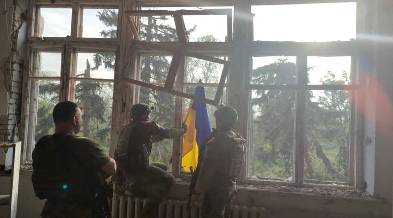 © Reuters. Ukrainian soldiers place a Ukrainian flag at a building, during an operation that claims to liberate the first village amid a counter-offensive, in a location given as Blahodatne, Donetsk Region, Ukraine, in this screengrab taken from a handout video released on June 11, 2023. 68th Separate Hunting Brigade 'Oleksy Dovbusha'/Handout via REUTERS