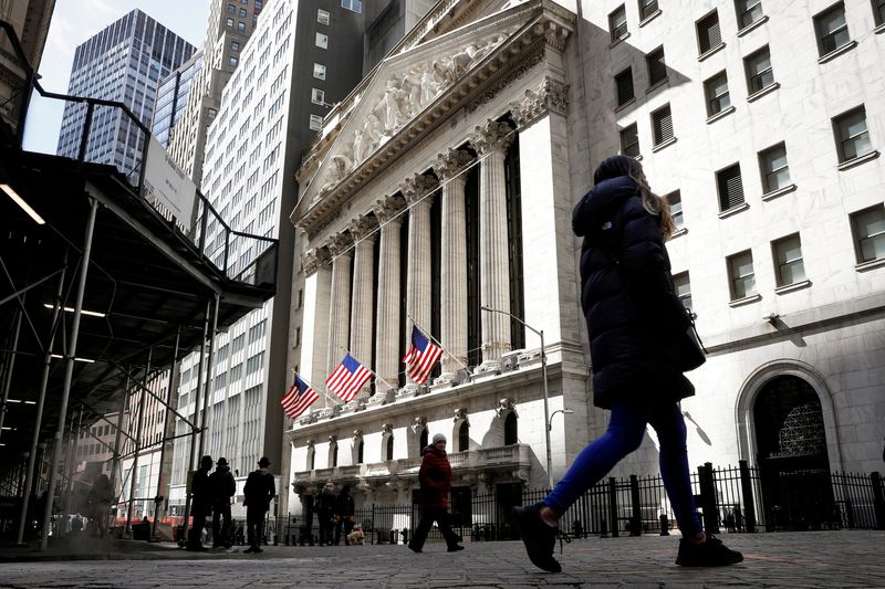 &copy; Reuters. Photo d'archives des piétons qui marchent devant l'enrée de la Bourse de New York (NYSE). /Photo prise le 19 mars 2021 à New York, Etats-Unis/REUTERS/Brendan McDermid