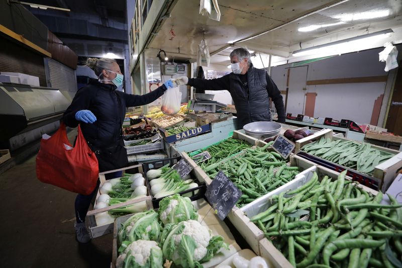 &copy; Reuters. A woman, wearing a protective face mask, shops for fruits and vegetables at a covered market in Nice as the spread of the coronavirus disease continues in France, April 1, 2020. REUTERS/Eric Gaillard