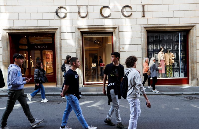 &copy; Reuters. Persone camminano fuori da un negozio Gucci a Roma, 20 aprile 2023. REUTERS/Remo Casilli